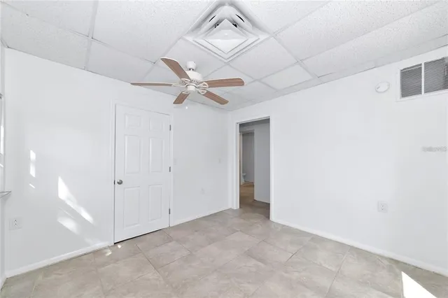an empty room with a ceiling fan and a window