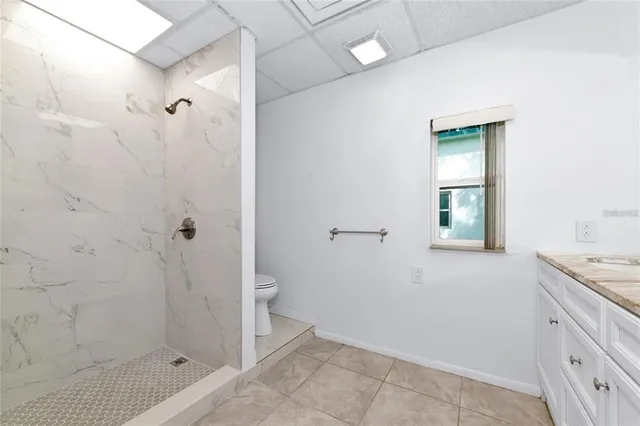 a bathroom with a granite countertop sink a toilet and shower