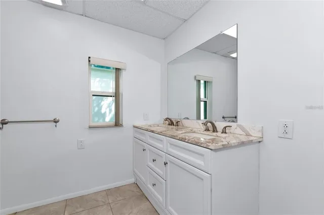 a bathroom with a granite countertop sink and a mirror