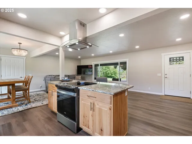 a kitchen with a stove and a wooden floor