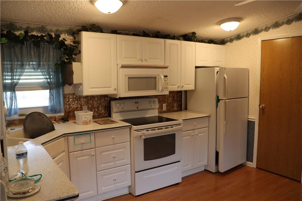 2495 Leach Road Linesville, PA 16424 - Photo 20 of 27 a kitchen with a refrigerator sink and cabinets