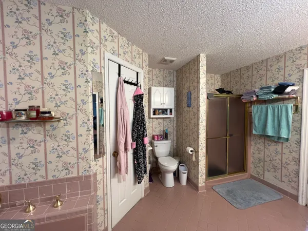 a bath tub sitting next to a white sink and a window