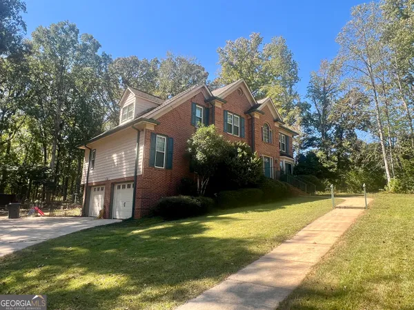 a view of a house with pool and trees in the background