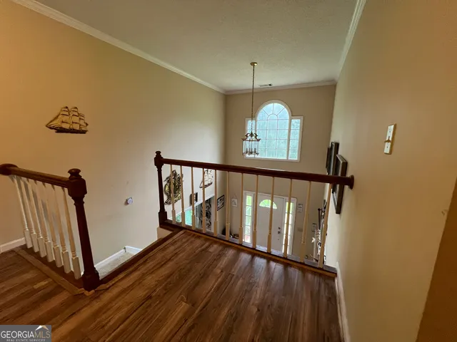 a view of staircase with lots of frames on wall and wooden floor