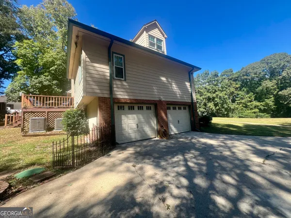 a view of a house with a yard potted plants and a large tree