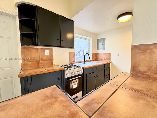 a kitchen with stainless steel appliances granite countertop a sink and a stove