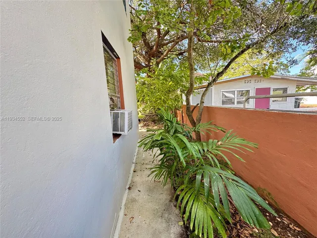 an aerial view of residential house with outdoor space and trees all around