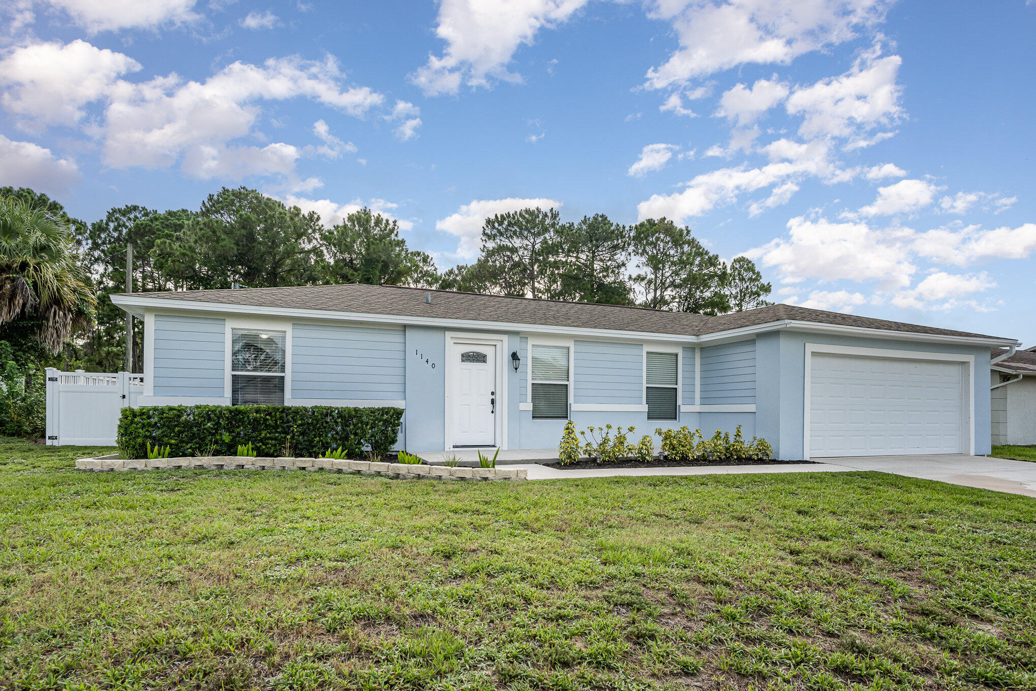 1140 Commerce Road Southeast Palm Bay, FL 32909 - Photo 3 of 24 a front view of house with yard and trees in the background