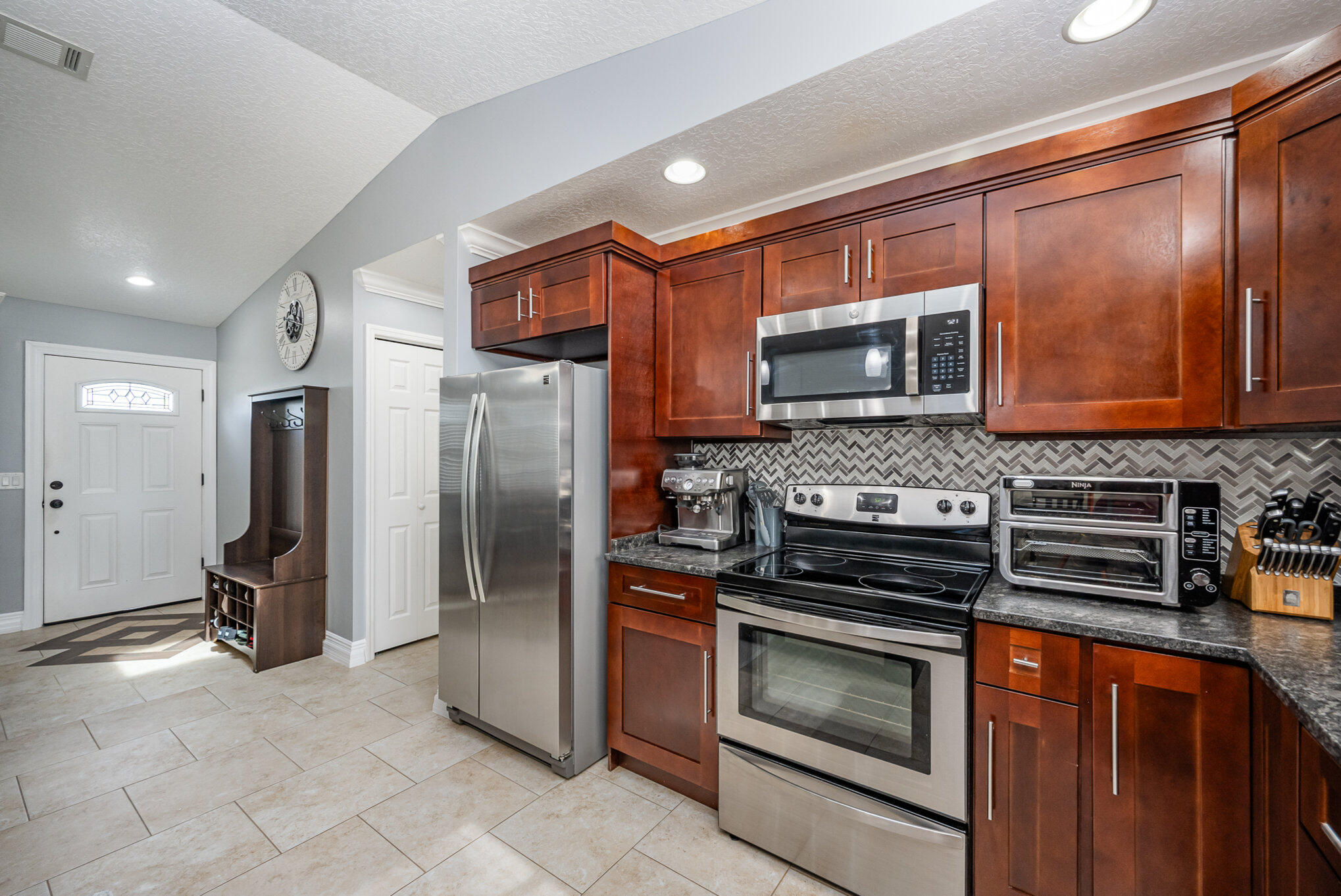 1140 Commerce Road Southeast Palm Bay, FL 32909 - Photo 7 of 24 a kitchen with granite countertop a refrigerator stove and microwave