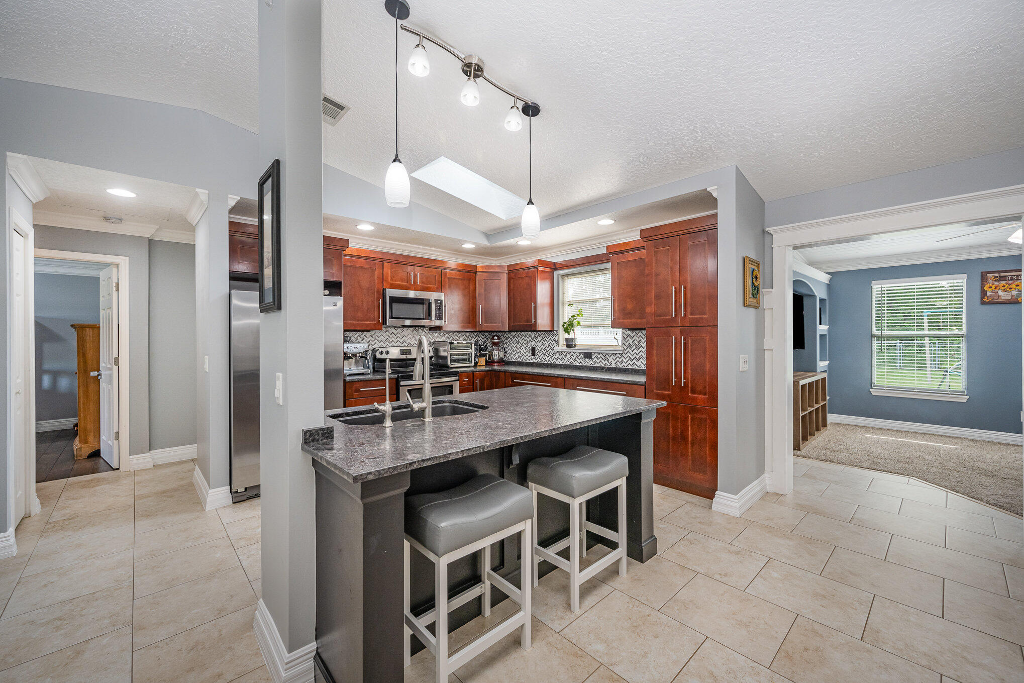 1140 Commerce Road Southeast Palm Bay, FL 32909 - Photo 9 of 24 a kitchen with stainless steel appliances kitchen island granite countertop a refrigerator a stove and a sink with granite countertops