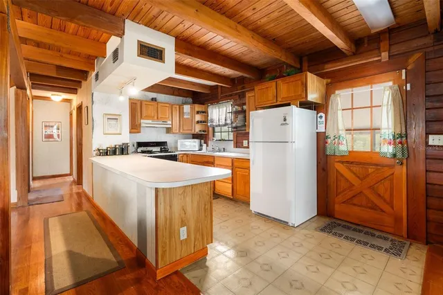 a kitchen with stainless steel appliances granite countertop a refrigerator a stove and a sink with wooden floor