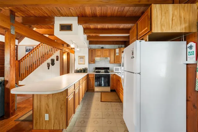 a living room with stainless steel appliances kitchen island granite countertop furniture and a large window