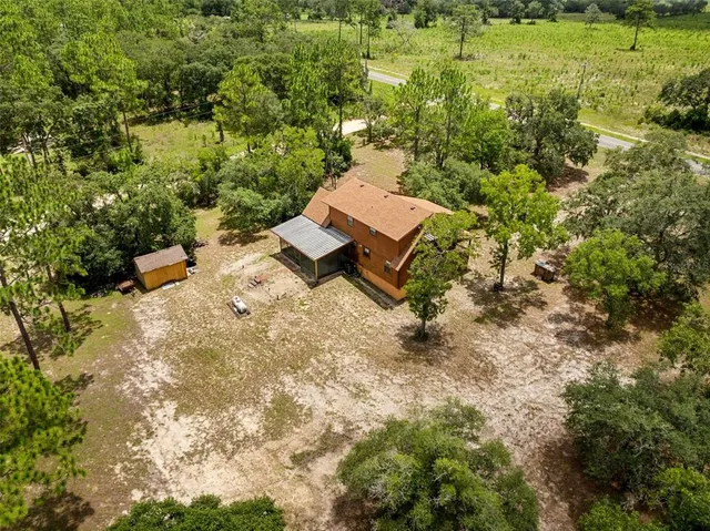 an aerial view of a house with a yard basket ball court and outdoor seating