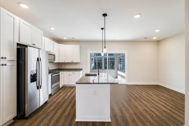 a kitchen with kitchen island a counter top space appliances and cabinets