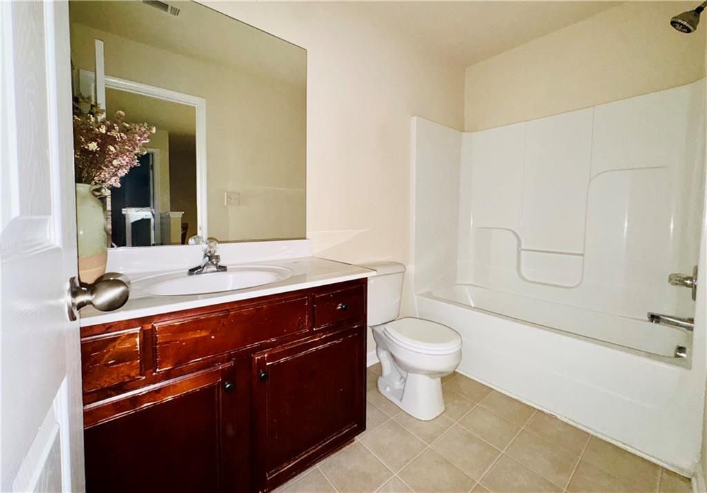164 Thorncrest Court Tucker, GA 30084 - Photo 25 of 26 a bathroom with a sink a toilet a mirror and shower