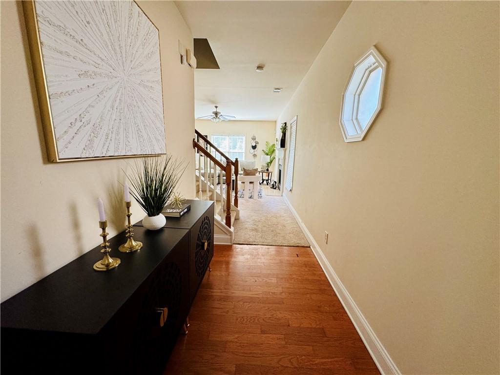 164 Thorncrest Court Tucker, GA 30084 - Photo 4 of 26 a hallway with wooden floor stairs and a chandelier