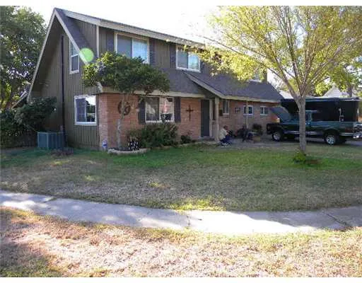 a view of a yard in front of a house with large tree