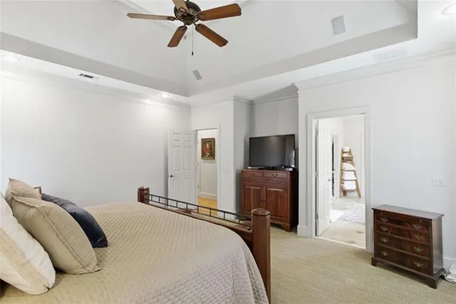 a bedroom with a bed and a flat tv screen on a dresser