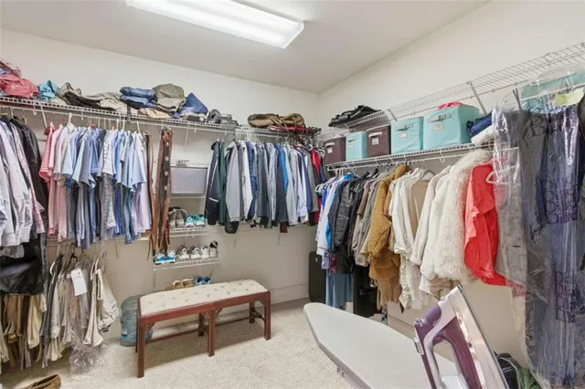 a view of walk in closet with clothes and shoes