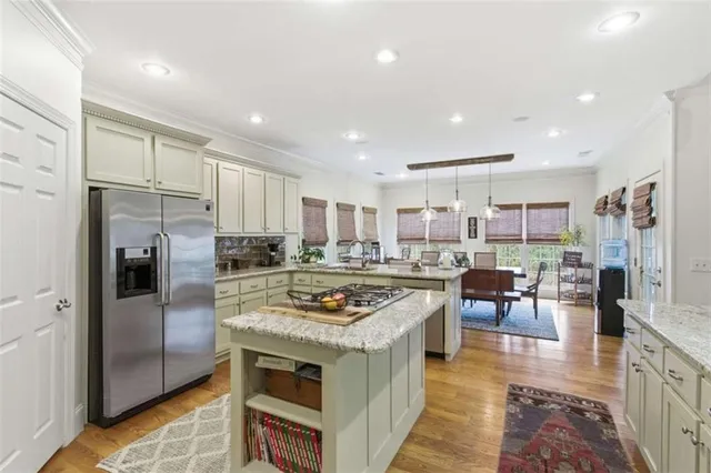 a kitchen with kitchen island stainless steel appliances a sink stove and refrigerator