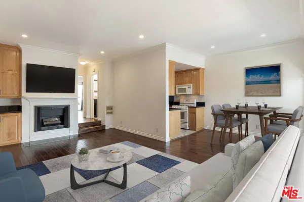 a living room with furniture a flat screen tv and kitchen view