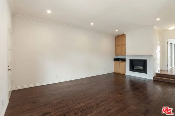 a view of empty room with wooden floor and fireplace