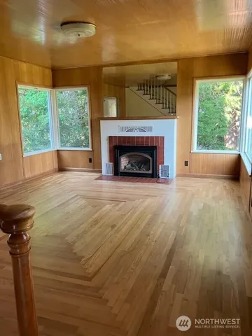 a view of empty room with wooden floor and fireplace