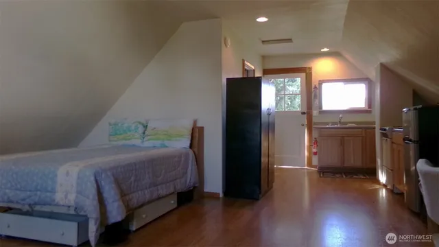 a bedroom with a bed and wooden floor