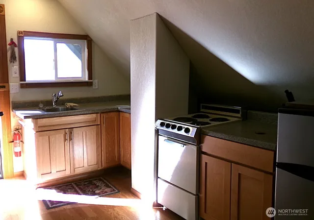 a kitchen with a sink a stove and a microwave