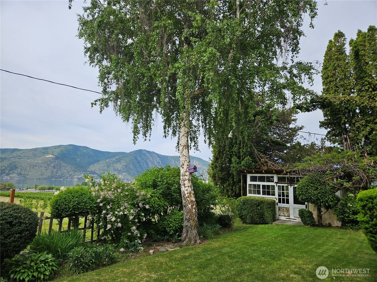 1555 Swartout Road Manson, WA 98831 - Photo 8 of 40 a view of a house with a yard and a garden