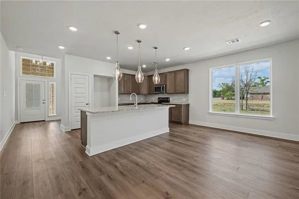 a bathroom with a granite countertop sink a toilet and shower