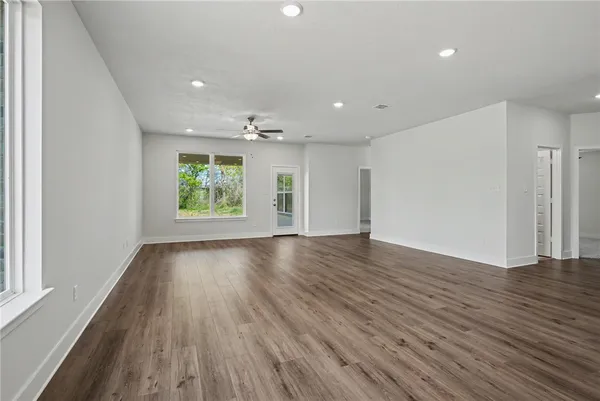 an empty room with a window and a fan