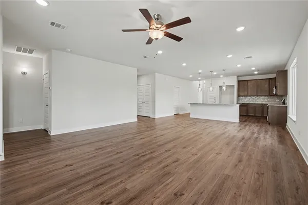 an empty room with closet and a ceiling fan
