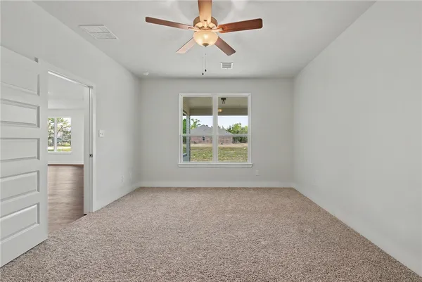 an empty room with closet and a chandelier fan