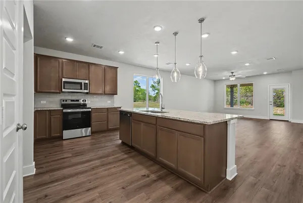 a view of kitchen with wooden floor and electronic appliances