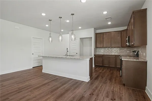 an empty room with windows and ceiling fan
