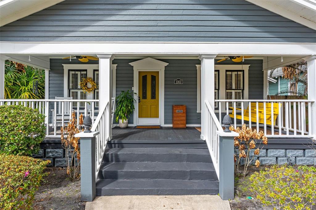 a view of a house with large windows and plants