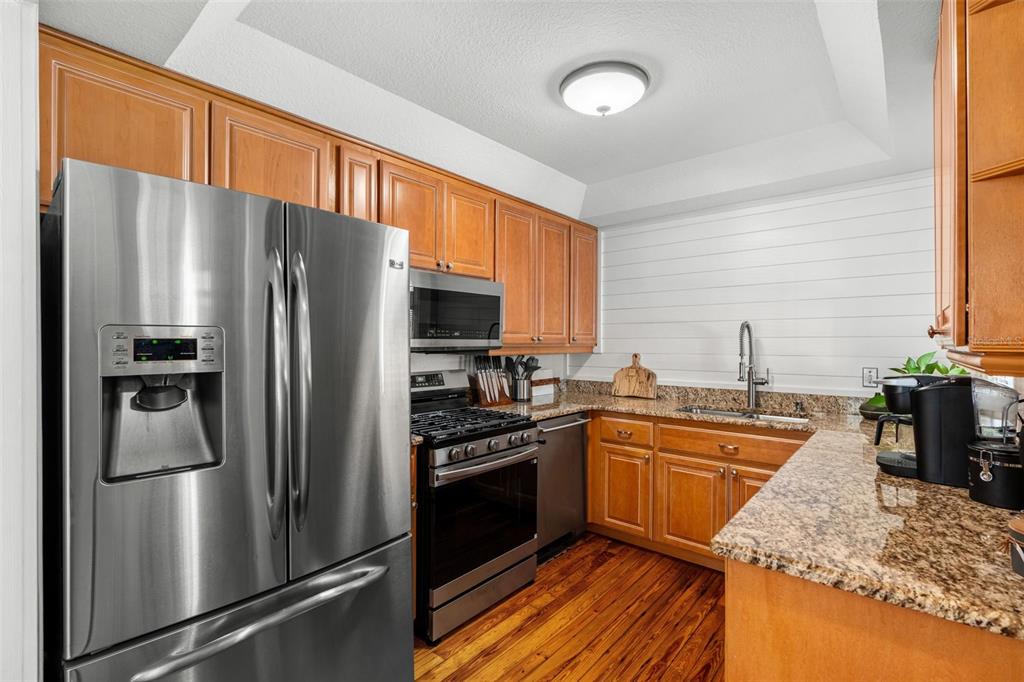 1003 East Jackson Street Orlando, FL 32801 - Photo 8 of 27 a kitchen with stainless steel appliances granite countertop a refrigerator a stove a sink and a microwave