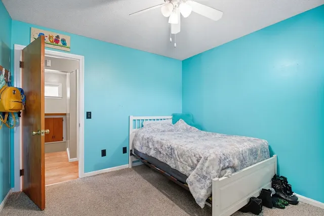 a bedroom with a bed a chair and a large window