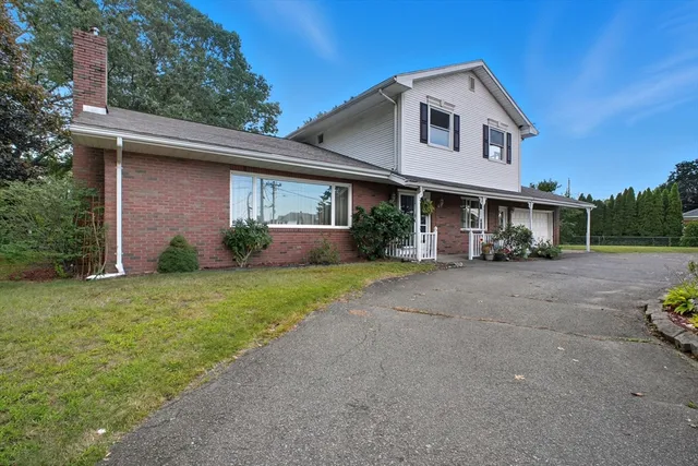 a front view of a house with a yard and potted plants