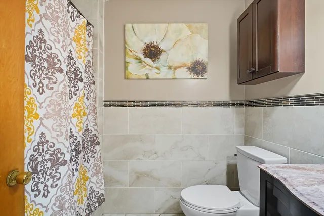 a bathroom with a granite countertop toilet sink and mirror
