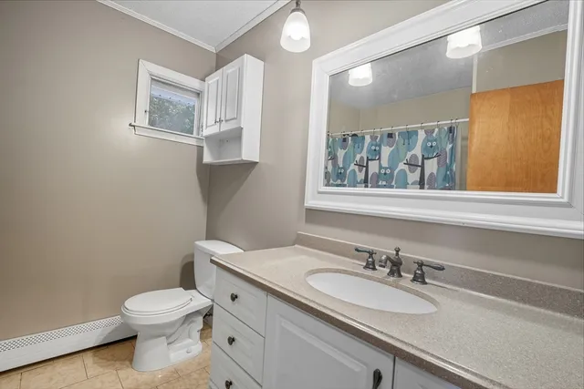 a bathroom with a toilet a sink a window and mirror