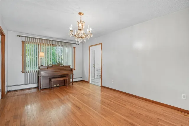 a room with a piano table and wooden floor