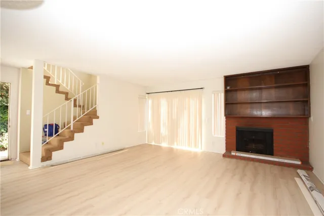a view of an empty room with a fireplace and a window