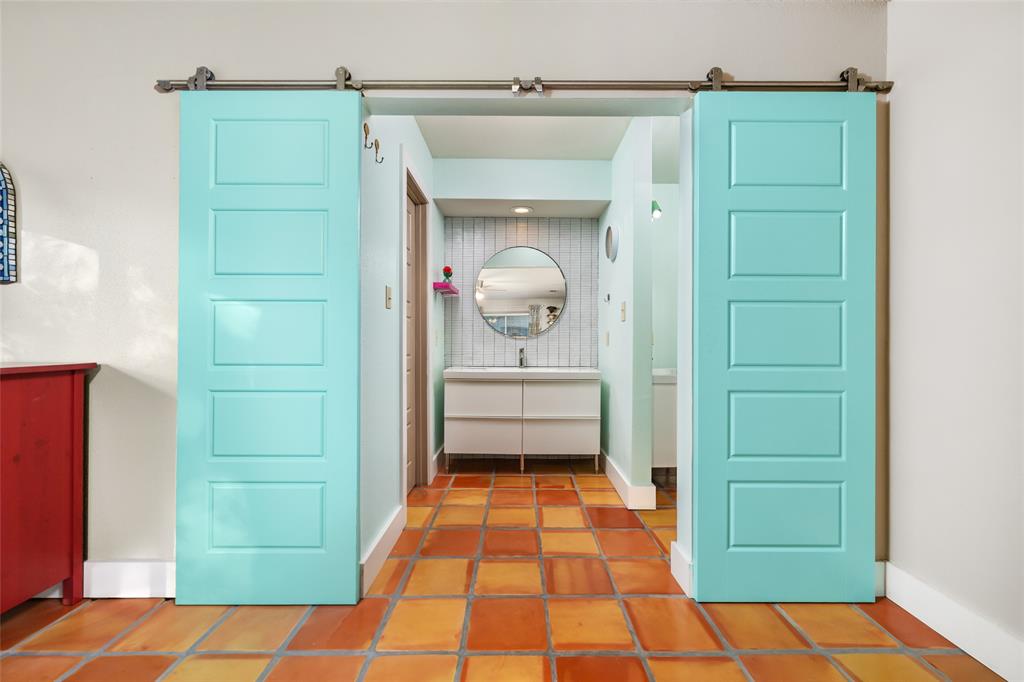 2210 Red Fox Road Austin, TX 78734 - Photo 27 of 40 Functional barn doors reveal a vibrant bathroom featuring a contemporary vanity.