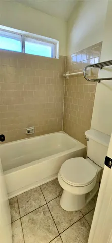 a white toilet sitting next to a bath tub and a shower