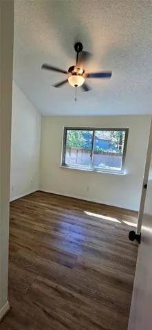 a view of a room with wooden floor and fan