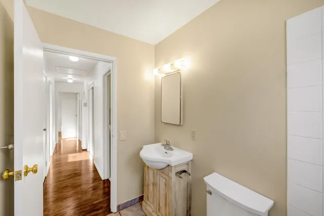 a view of a hallway with wooden floor and a potted plant