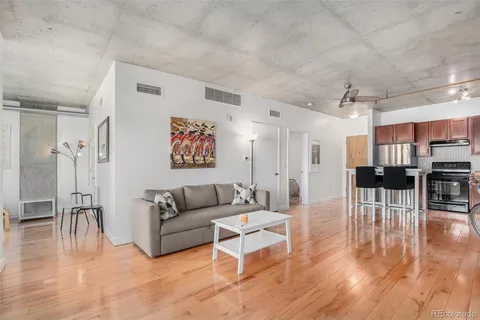 a living room with furniture and a wooden floor