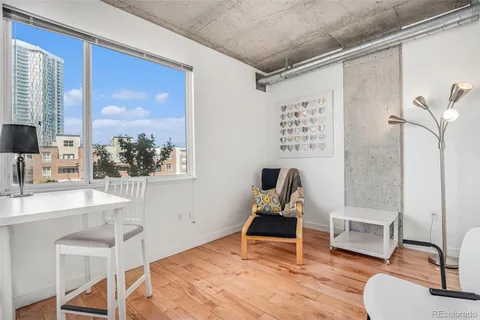 a living room with wooden floor furniture and a window